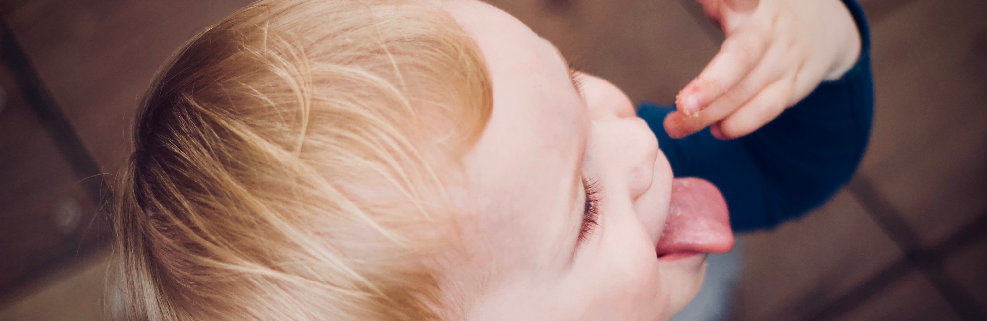 toddler with strawberry blonde hair snacks
