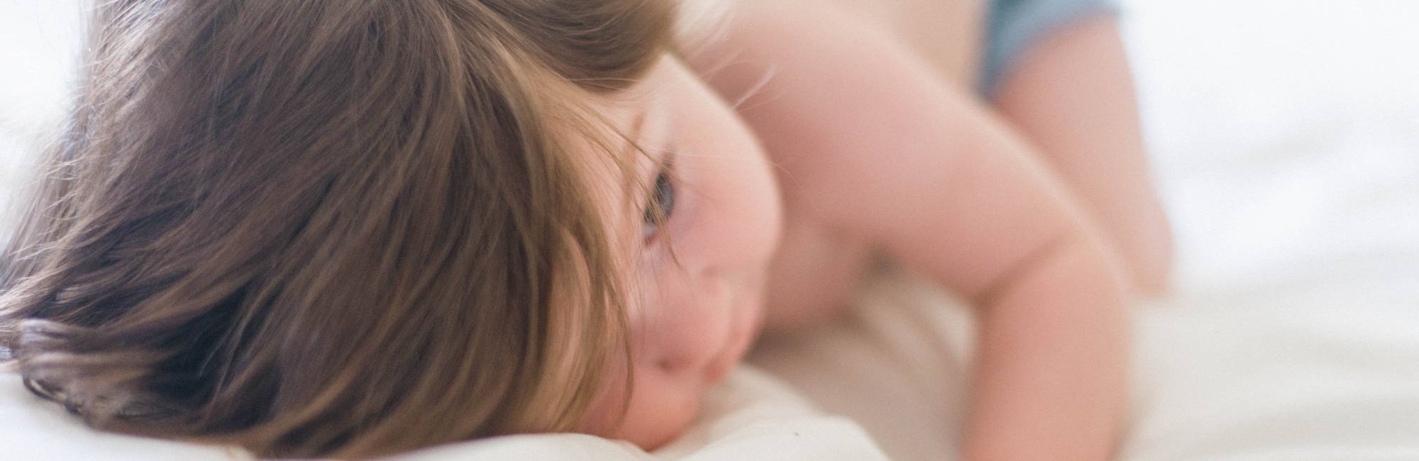 toddler laying down in bed in the daytime