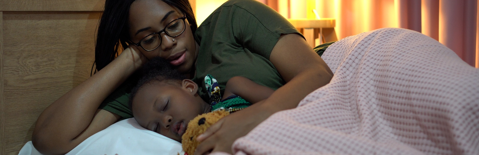 mother and her child cuddle up in bed